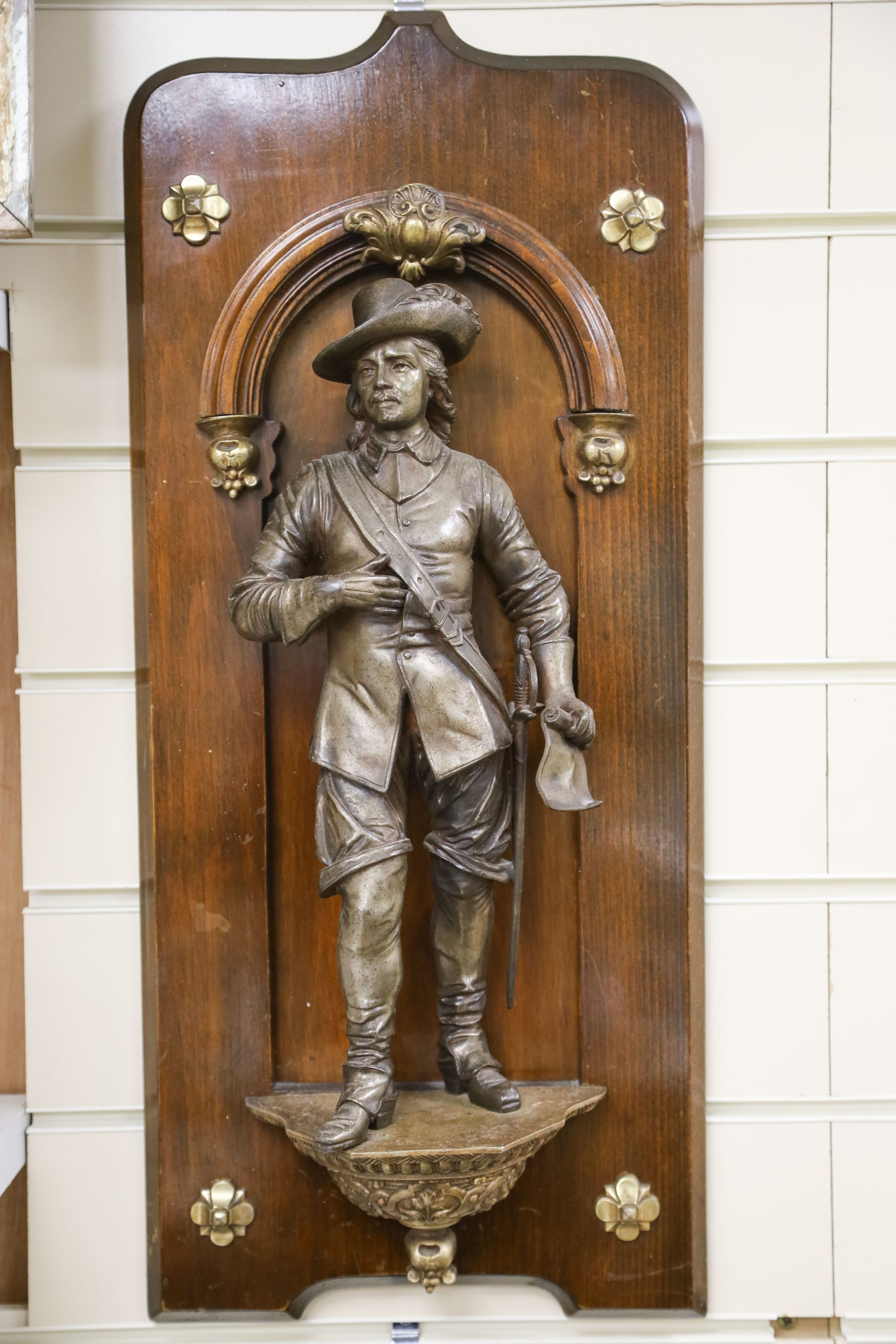 A pair of cast spelter figures of a medieval knight and a cavalier, each mounted on a mahogany niche